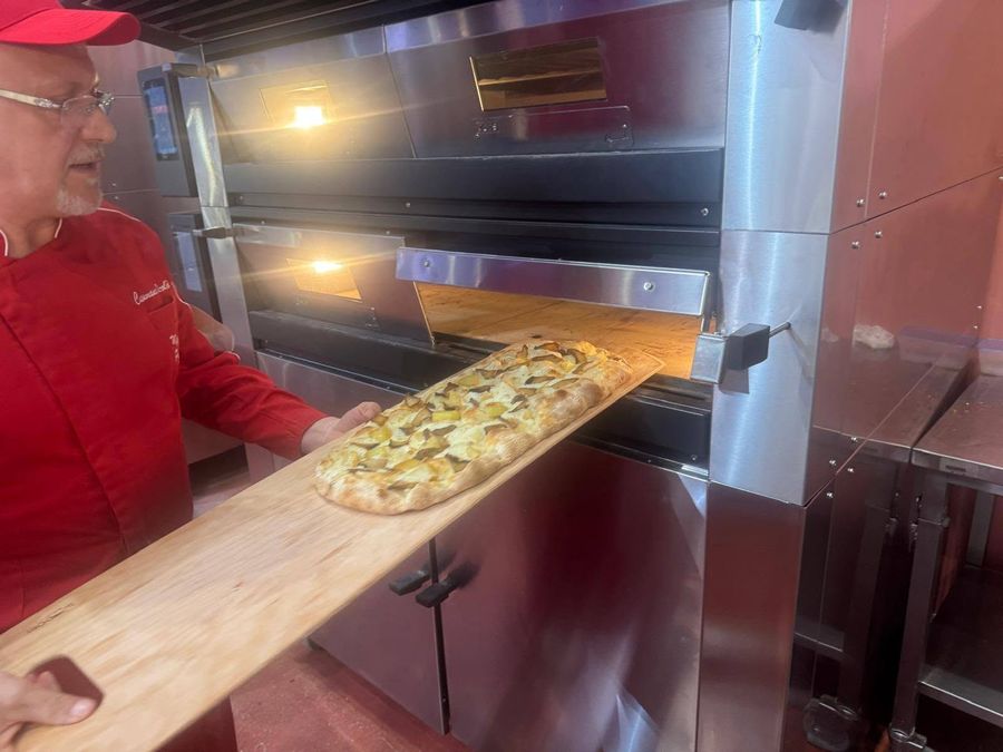 Nicolò inforna una pizza in pala