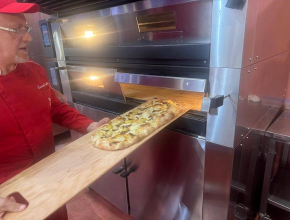 Nicolò inforna una pizza in pala