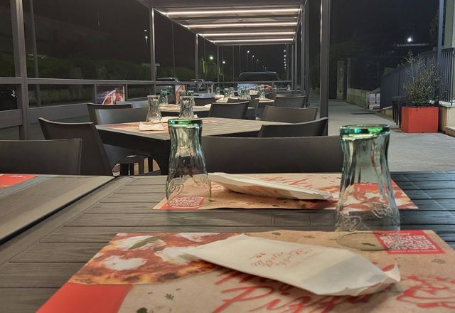 Un tavolo apparecchiato nella veranda, la sera